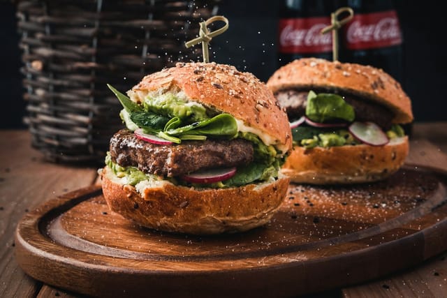Dos hamburguesas sobre una tabla de madera